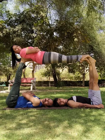 A fun, multi person acro yoga pose that creates a human table. This kind of partner yoga is a fantastic way to build core strength and stability while having a great time with friends.