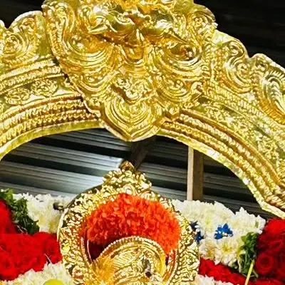 A close-up of the ornate golden arch (prabhavali) above a deity, a key element in traditional idol decoration.
