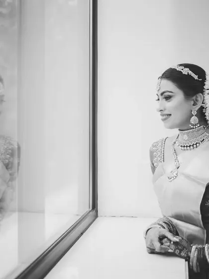 A beautiful black and white portrait of the bride, Aashna, looking at her reflection, creating a sense of depth and story.