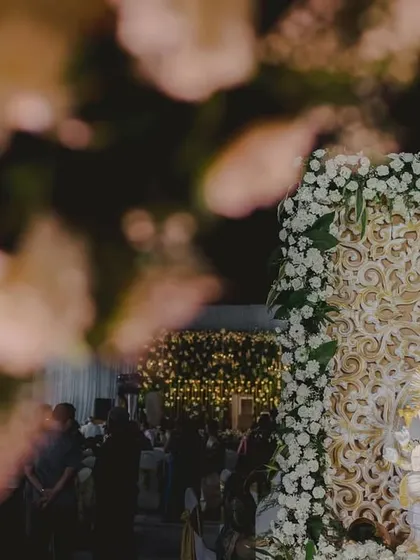 An artistic shot of a Ganesha idol decorated with white florals, framed by the beautiful carnation decor of the main event.