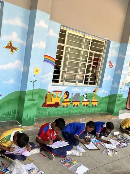 Students find their creative space against a colorful, animal-themed mural. A vibrant environment inspires vibrant minds, and we love creating spaces where children feel happy and motivated.