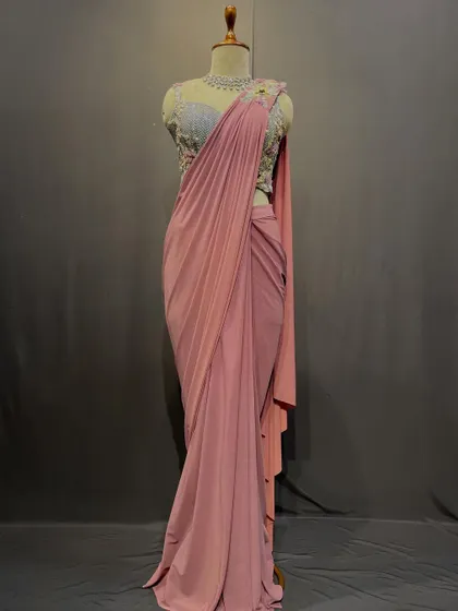 Pastel whispers and intricate blooms. This soft pink drape saree with a silver embroidered blouse is a story of timeless grace.