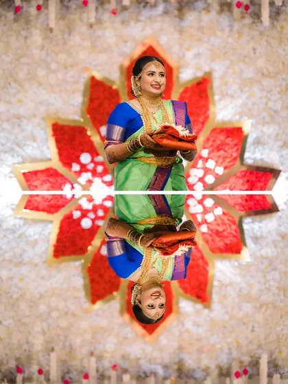 An artistic shot of the bride with her reflection, standing before the striking red lotus backdrop.
