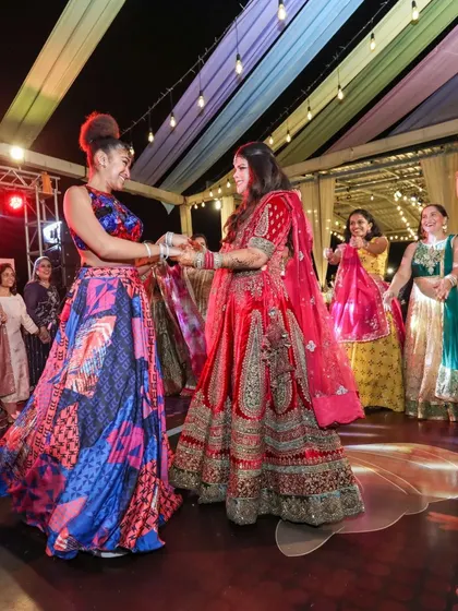The Sangeet is a night of pure celebration. The couple and their guests enjoy the performances under a canopy of colorful drapes and lights, a signature of the vibrant events we plan.