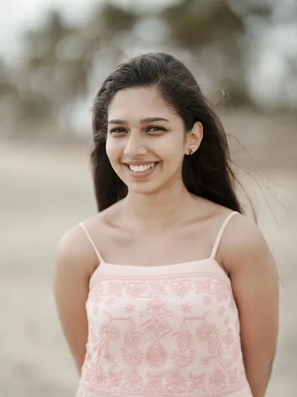 A simple, beautiful, and natural portrait. The close-up shot and her genuine smile create an honest and engaging image that truly captures her personality without any distractions.