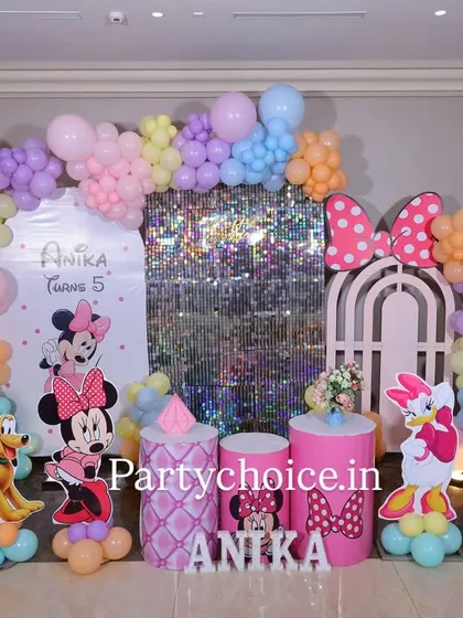 This Minnie Mouse birthday party is a pastel dream. The setup includes a shimmering sequin panel, a custom arch, and character cutouts of Minnie, Daisy, and Pluto, all tied together with a soft, multi-colored balloon garland.