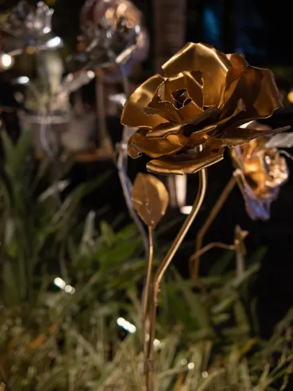A close-up of a handcrafted golden rose sculpture. These unique, artistic elements were scattered throughout the event space, adding a touch of bespoke glamour.