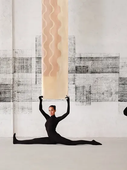 Models in black catsuits interact with suspended Banarasi textiles, showcasing the fabric's lightness and color in a dynamic, gravity-defying way.