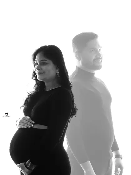An artistic double exposure effect. This creative shot blends the mother-to-be in the foreground with the father-to-be in the background, symbolizing their shared journey.
