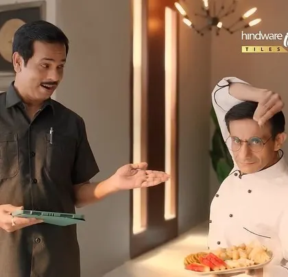 A funny moment from the Hindware ad, where a chef appears unexpectedly. The contrast between the chef's uniform and the homeowner's casual shirt is part of the humor.