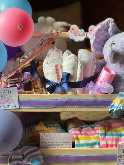 A closer look at the newborn hamper, focusing on the plush elephant and neatly rolled diapers tied with a ribbon. It’s a gift that is both adorable and practical.