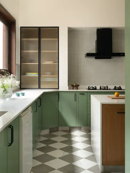 A built-in pantry cabinet with glass shutters provides beautiful and practical storage in the kitchen. The design balances open and closed storage to keep the space feeling organized and airy.
