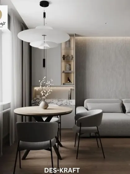 The open-concept design connects the kitchen and dining areas, with a sculptural pendant light hanging over the dining table, creating a distinct zone.