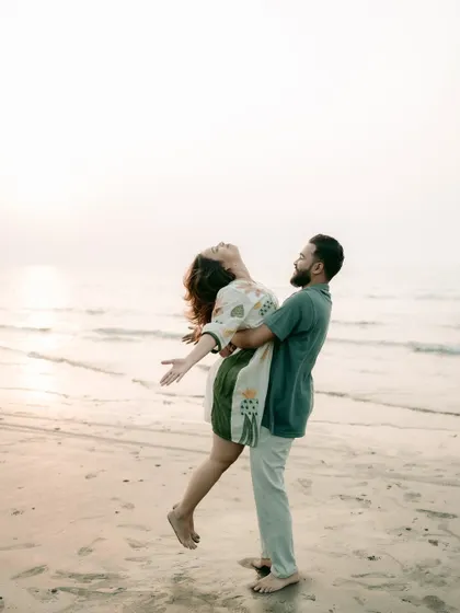 A joyful and liberating pose against the ocean backdrop. This kind of shot perfectly captures the feeling of starting a new life together.
