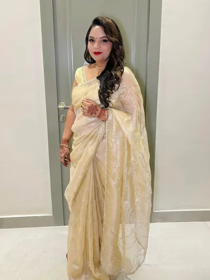 A full-length shot of the client in her golden saree.