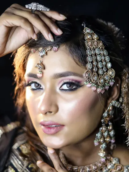 A modern bridal look with soft pink tones and dramatic jewelry. Our students are trained to adapt to contemporary bridal trends.