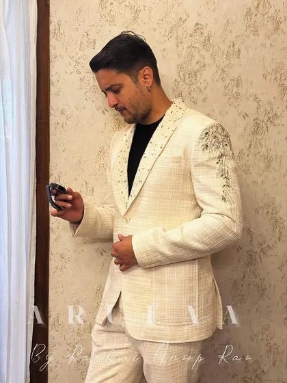 A side profile of the handcrafted linen suit, showing the intricate embroidery detail on the shoulder. It's these subtle, custom touches that make a bespoke piece special.