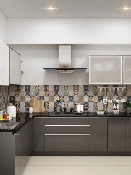 This L-shaped kitchen features glossy grey cabinets and a colorful, patterned tile backsplash. The handleless design keeps the look clean and modern.