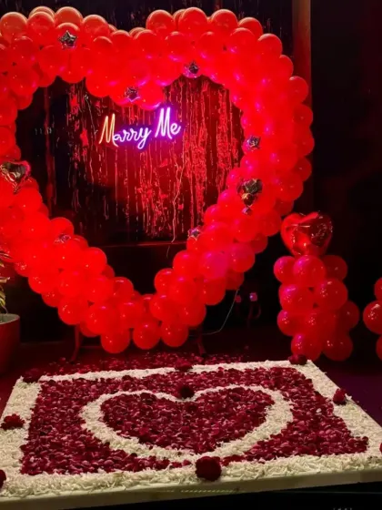 Another angle of the vibrant red balloon heart proposal setup. The design includes cute balloon teddy bears and a beautifully arranged heart-on-heart rose petal design on the floor.