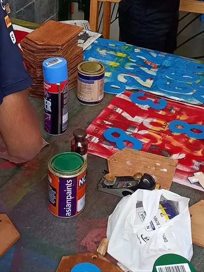 The painting and finishing stage of the scoreboard project. The numbers are painted in house colors before being attached.