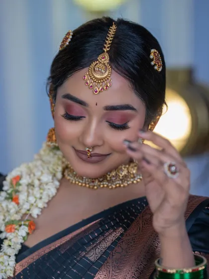 A close-up on the eye makeup and the detailed maang tikka and hair accessories that are part of our bridal jewellery sets.