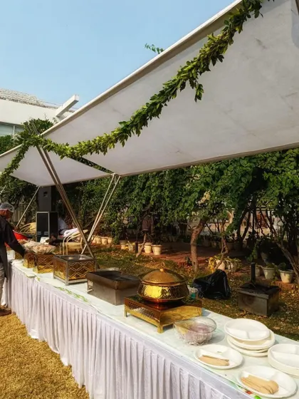 Even the catering area was designed to match the elegant theme. The white canopy is decorated with a simple green garland, ensuring a cohesive look throughout the event space.