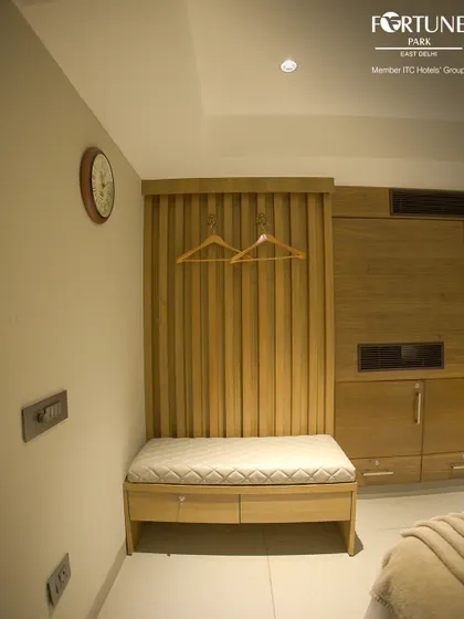 We provide practical storage solutions in every room, like this cushioned luggage bench with drawers and a dedicated space for hanging clothes.