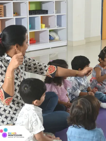 An adult engages with a group of children, demonstrating a lesson with enthusiasm. Our educators are passionate about creating joyful learning experiences.