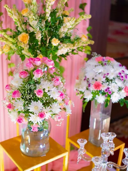 More details of the lotus-themed decor. The combination of fresh flowers in glass vases and the soft pink backdrop created a delicate and elegant atmosphere for the naming ceremony.