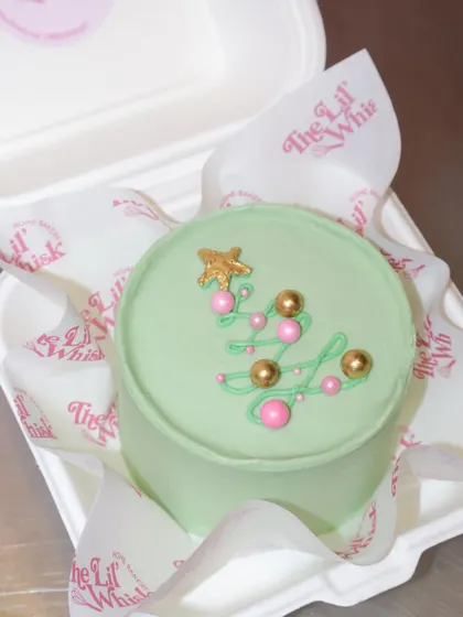 A minimalist and modern Christmas bento cake. The simple green tree with pink and gold ornaments is chic and festive.