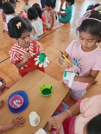 Two children are deeply focused on painting their craft projects. Art helps develop concentration and attention to detail in a fun and engaging way.