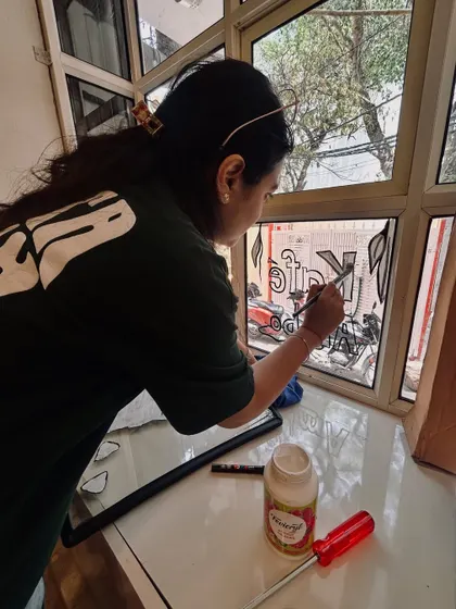 Sometimes the canvas isn't a wall, but glass. Here I am, lost in the process of painting custom illustrations directly onto the window panels of a cafe.