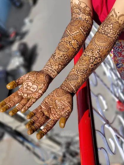 This is the same beautiful personalized design with the 'Raja weds Rani' heart. The full view shows how the personal element is the centerpiece of the entire palm design.