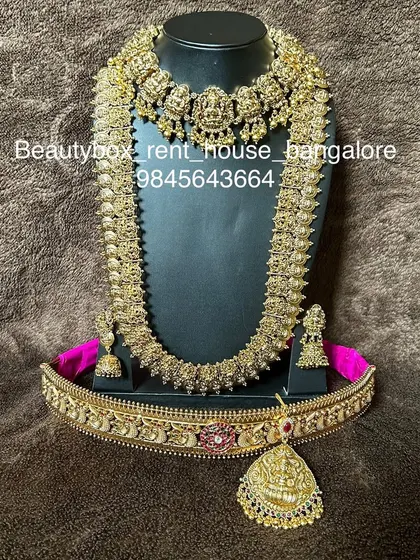 A beautiful antique coin (kasu) necklace set, including a choker, a long kasu haram, and a matching vaddanam. A very popular rental for its traditional appeal.