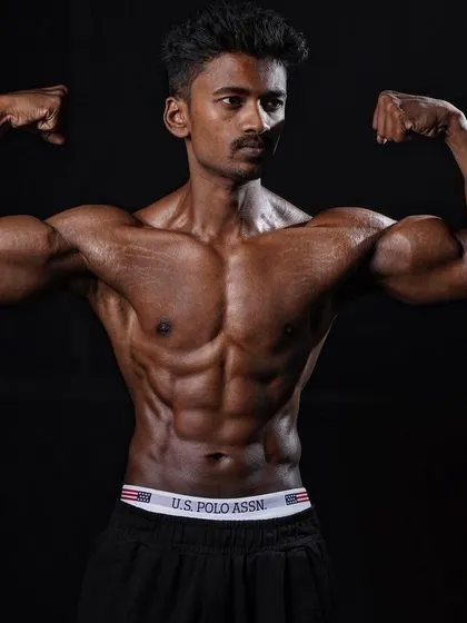 A classic front double bicep pose from a client who went from obesity to shredded. This pose shows off his new V-taper and arm development.