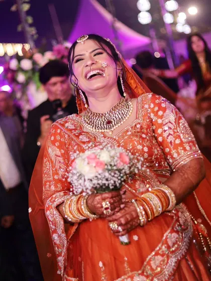 The pure, unadulterated laughter of the bride during her entrance. This candid shot is full of life and happiness.