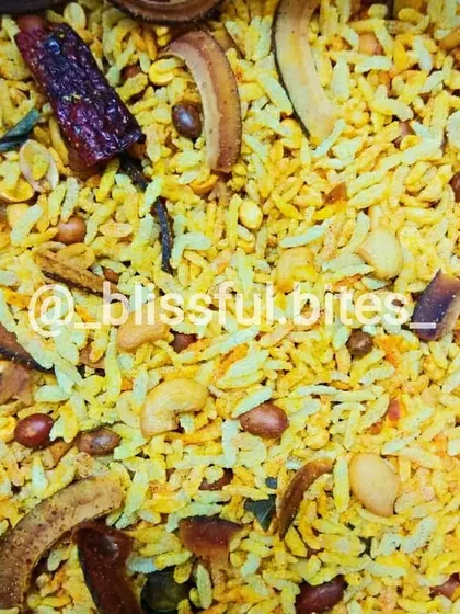 A close-up of the ingredients in my Memon Chivda, including fried coconut slices, peanuts, cashews, and spices.
