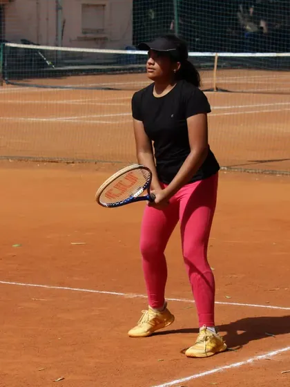 A player focused and ready to receive a serve during a tournament. The ready position is fundamental to a quick and effective response.