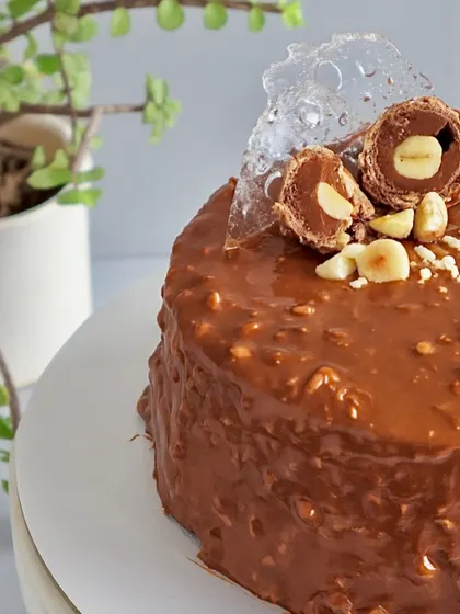 This is my signature Almond Rocher Cake, and it's a bestseller for a reason. It has layers of rich chocolate sponge and Nutella ganache, all wrapped in a crunchy almond chocolate glaze. It’s pure indulgence with a satisfying crunch in every bite.