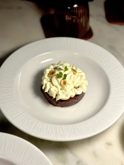 A beautifully plated dessert from our Valentine's menu, topped with whipped cream and hazelnuts.