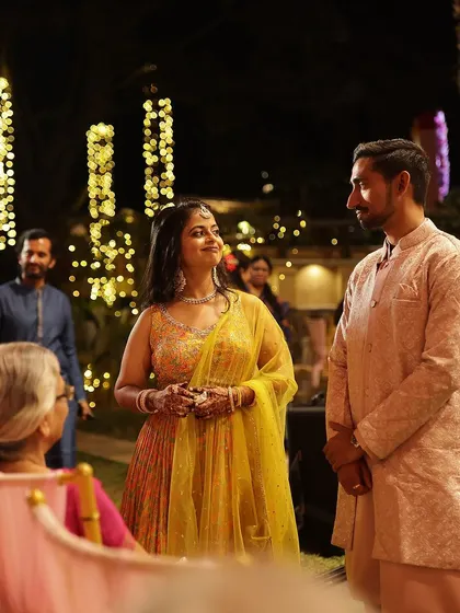 A candid moment between the couple at their reception, with the bride's elegant mehendi visible.