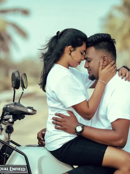 An intimate and cool moment on a Royal Enfield. This close-up shot focuses on the couple's connection and shared love for adventure.