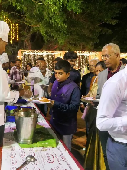A guest being served at a live food counter during an evening function. My chefs are always ready to serve with a professional and welcoming attitude.
