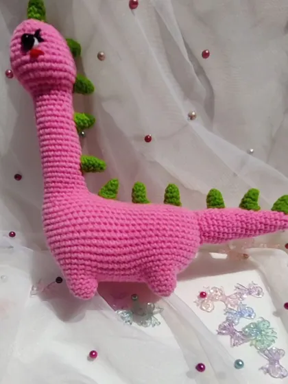 Meet Mrs. Dino, a lovely pink dinosaur with green spikes.