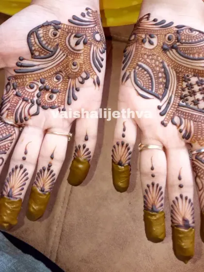 A beautiful Arabic design with a feather-like pattern on the fingers. The style is very elegant and provides a good amount of coverage.