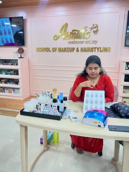 A trainer showcasing a board of nail designs that students will learn to create.