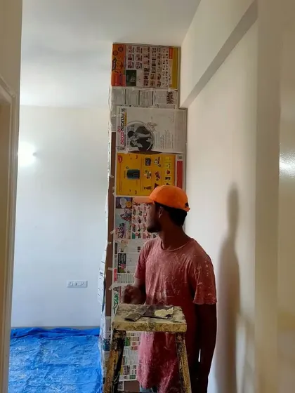 This painter is taking a moment to assess the wall surface before proceeding. This attention to detail at every step ensures the final outcome is nothing short of perfect.