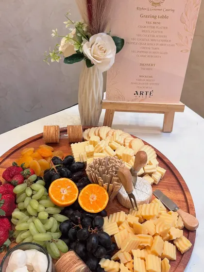 A beautiful wooden board laden with fresh strawberries, grapes, and a variety of cheeses, including a wheel of Brie. This platter was part of a larger grazing table for a salon event, showcasing a fresh and inviting selection.