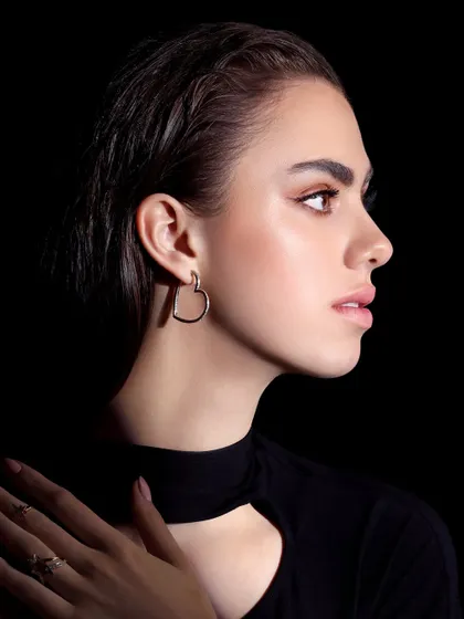 A profile shot from the Farah Khan campaign, using shadow to create a dramatic, high-fashion look while highlighting the heart-shaped earring.