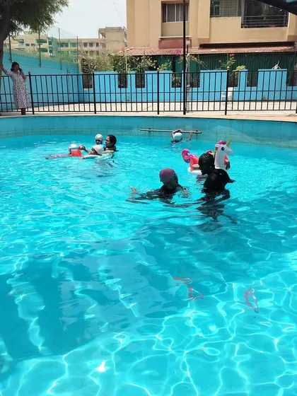 Kids enjoying the water with floaties and instructor support, making learning to swim a safe and positive experience.